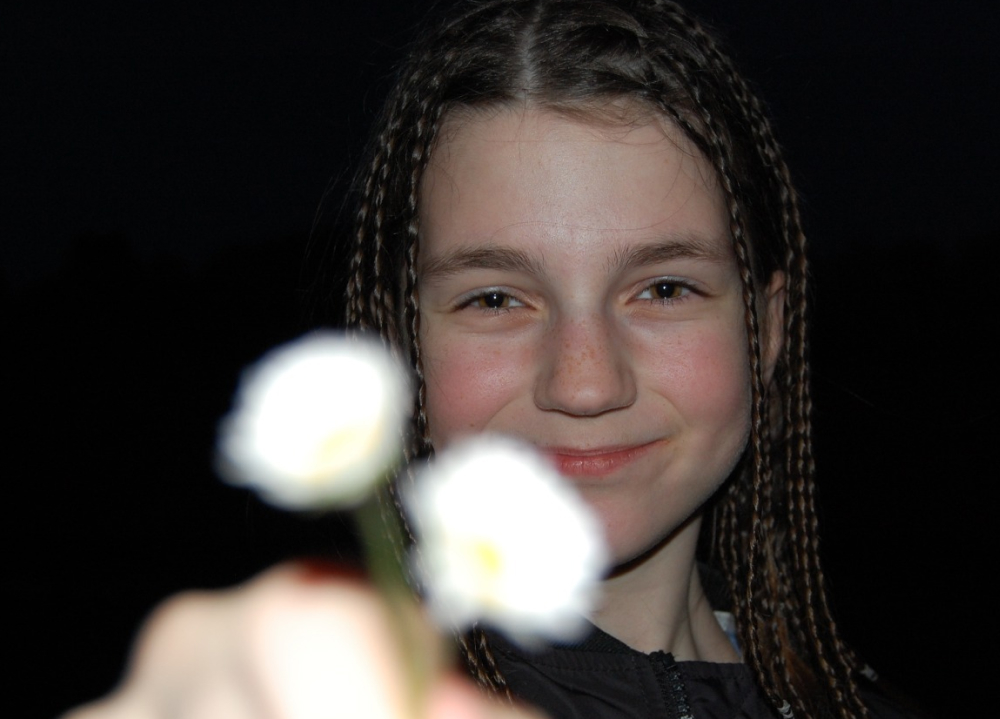 Schülerin zeigt eine weiße Blume